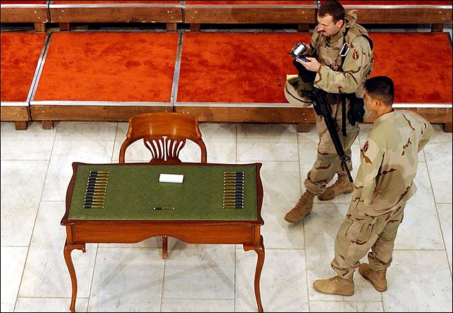 An American soldier filmed the table, which once belonged to King Faisal, and the 25 pens that were to have been used by Iraqi leaders to sign their temporary constitution but the ceremony was canceled, Baghdad, March 5, 2004.